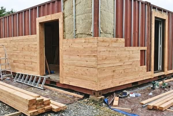 Cedar cladding being installed on a container